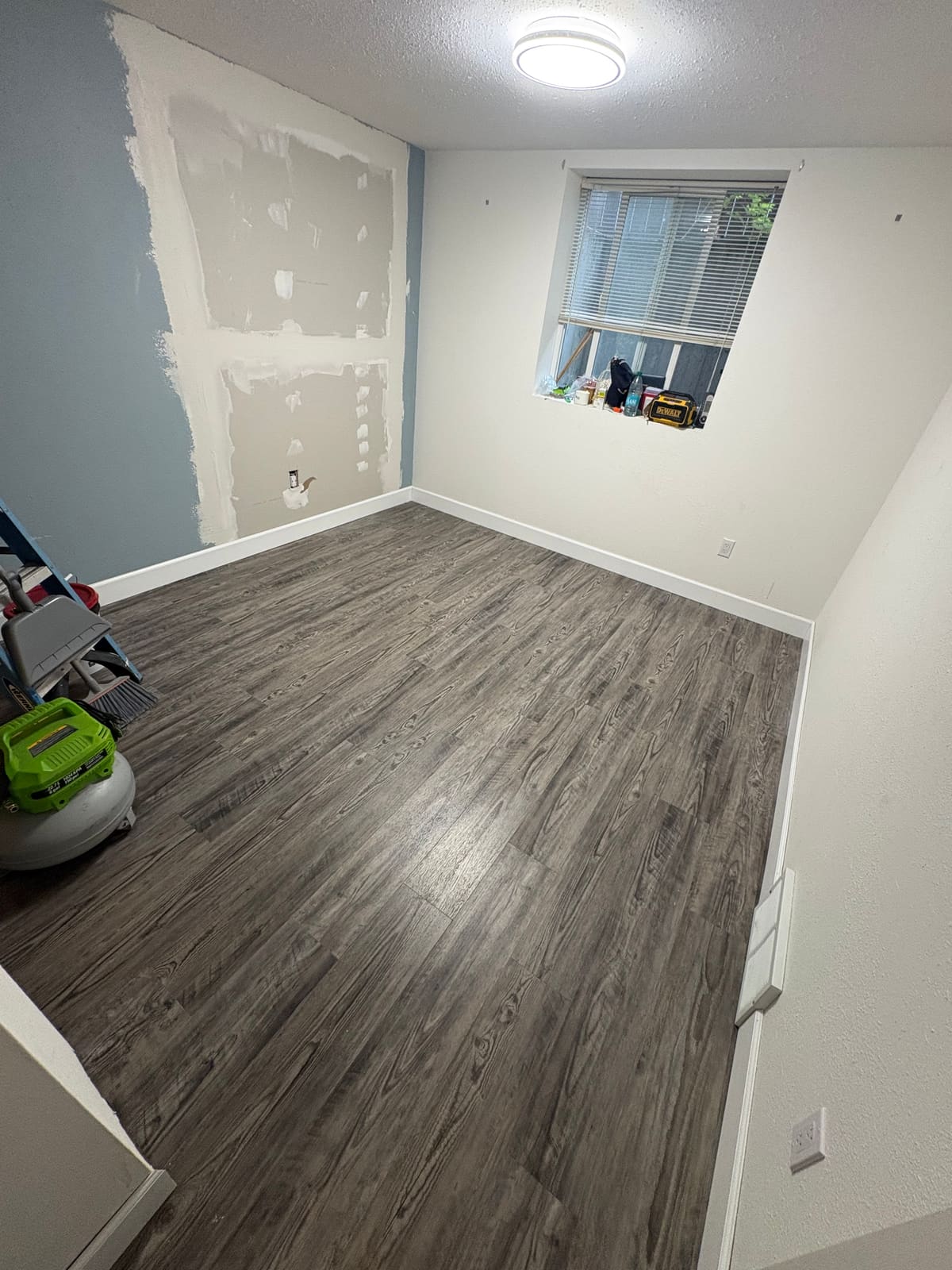 Room with repaired drywall, reinstalled flooring and new baseboard trim